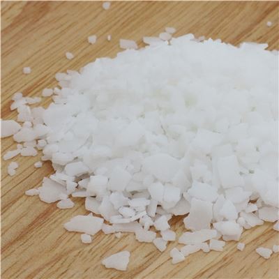 Close-up of white myristic acid flakes on a wooden surface